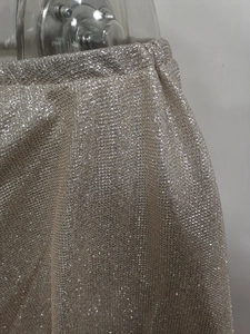Detail of silver sparkling fabric with metallic thread and elastic waist on the dress