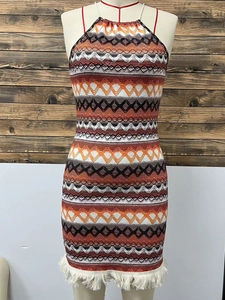 Dettaglio dell'abito boho a fascia con motivi geometrici e frange bianche sull'orlo