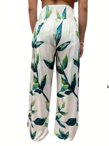 Detail of high-waisted wide-leg pants featuring smocked elastic waist and tropical leaves