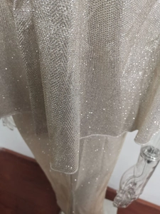 Close-up of sparkling silver mesh fabric with shimmering glitter for evening dresses