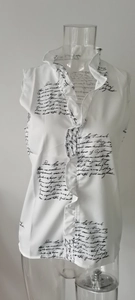 Detail of white sleeveless shirt featuring ruffle stand collar and black script print