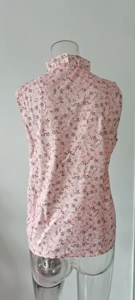 Detail view of pink floral sleeveless blouse back with ruffled collar and print