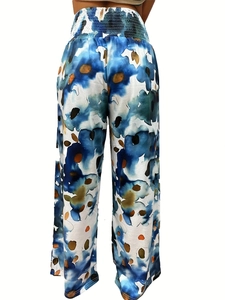 Detail view of high-waist smocked elastic band on floral print wide-leg trousers