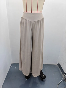 Détail du pantalon large à taille haute avec taille élastique et tissu plissé fluide