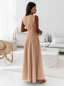 Détail d'une robe longue abricot avec ceinture dans un décor intérieur minimaliste