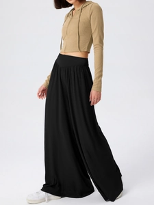Détail du pantalon large noir à taille haute avec un tissu au drapé fluide et élégant