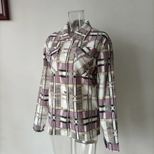 Detail view of plaid shirt jacket featuring chest pockets and metal button closures