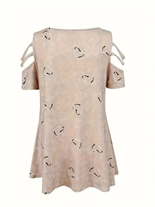 Detailed view of v-neck cold shoulder top with heart print and cross strap sleeve detail