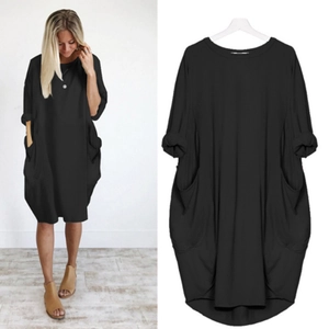 Détail de la robe noire ample à manches longues avec grandes poches et col rond