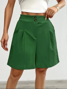 Detail view of high waisted dark green wide leg shorts with double buttons and pleated texture