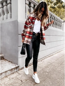 Detail of red and brown plaid flannel shirt jacket styled with black leather pants and belt