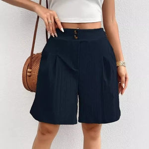 Detail of high-waisted navy wide-leg shorts with double button closure and pleated fabric
