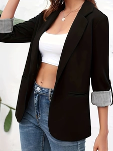 Detail of black slim-fit blazer showing stylish black and white striped sleeve linings