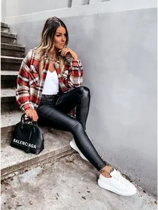 Fashionable red plaid shirt jacket with black faux leather leggings and white sneakers