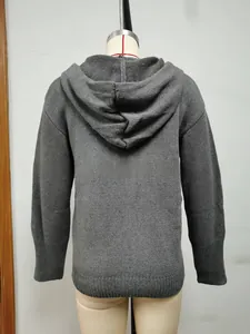Detail view of the dark grey knitted hoodie showing thick texture and ribbed cuffs