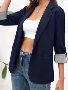 Detail of navy blazer featuring notched lapels and stylish striped lining on folded cuffs