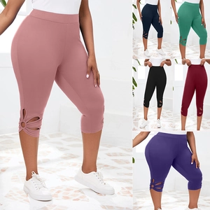 Détail de motifs floraux ajourés sur l'ourlet de leggings de sport capri multicolores