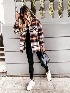 Detail of checkered flannel shirt with chest pockets and navy-orange plaid pattern
