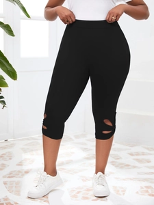 Détail du legging noir taille haute avec découpes ajourées sur les jambes latérales