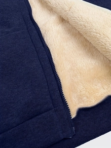 Detail of navy blue oversized hoodie with thick warm white faux fur lining and zipper