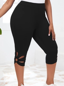 Détail de la découpe de fleurs ajourées sur l'ourlet du legging capri noir à taille haute