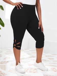 Détail du legging court noir à taille haute avec découpes latérales en forme de pétale