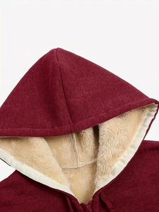 Close-up of wine red oversized hoodie showing warm cream fleece lining and zip detail