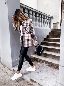 Detail of pink plaid long-sleeved shacket with flap pockets and buttoned cuffs