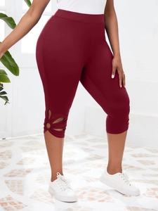 Détail de la découpe en forme de tournesol sur un legging de yoga bordeaux à taille haute