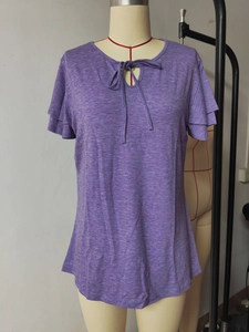 Detailed texture of purple knit fabric with V-neck bow tie and layered ruffle sleeves