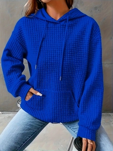 Close-up of women's hoodie featuring blue waffle knit texture and drawstring hood
