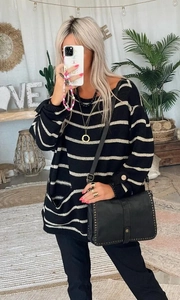 Dettaglio maglione oversize a righe con ampie tasche anteriori e polsini con bottoni