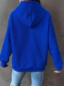 Close-up of royal blue waffle knit hoodie fabric and texture on model back view