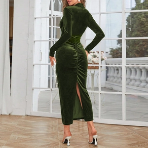Detail of ruched back seam and split hem on an elegant emerald green velvet maxi dress