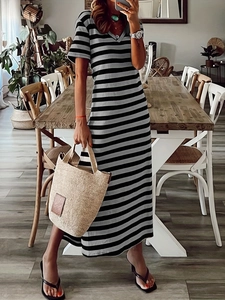 Mirror selfie showing a striped short-sleeve maxi dress and a woven straw tote bag