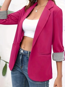 Detail of fuchsia blazer featuring stylish black and white striped cuffs on the sleeves