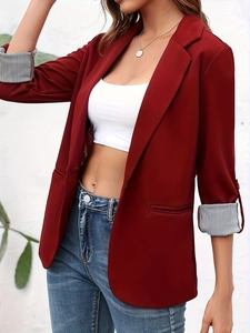 Detail of burgundy blazer featuring striped lining cuffs and elegant welt pockets