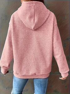 Detail view of pink waffle knit hoodie for women featuring dropped shoulders and ribbed hem