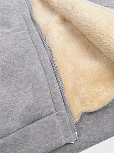 Detailed close-up of warm faux shearling lining and grey knit fabric on the hoodie