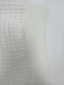 Detailed close-up showing white quilted texture and ribbed elastic cuff on women sweatshirt