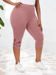 Détail de la découpe florale ajourée sur l'ourlet de ce legging capri rose poudré sport