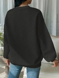 Women's black quilted waffle knit crewneck sweatshirt with dropped shoulders and ribbed cuffs