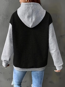 Close-up of waffle knit texture on oversized hooded sweatshirt with color-block back view
