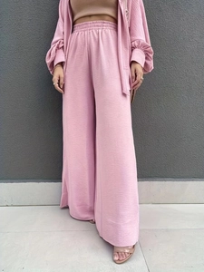Détail de la texture plissée légère sur l'ensemble pantalon taille haute et chemise rose