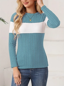 Detailaufnahme der eng anliegenden Strickoberteil mit blau-weißem Farbblockdesign