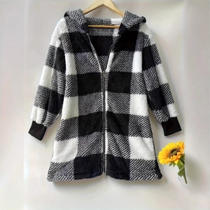 Close-up of plush black and white checkered hoodie with metallic zipper and ribbed cuffs