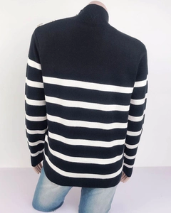 Dettaglio del maglione a righe blu con bottoni decorativi dorati sulla spalla