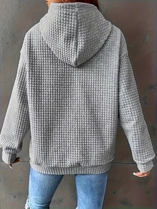 Back view of a grey hoodie featuring a waffle knit pattern and stylish dropped shoulders