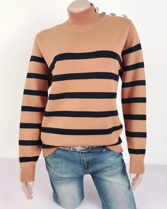 Dettaglio del maglione a righe a collo alto con bottoni metallici sulla spalla