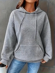 Detail of grey quilted texture fabric on a drawstring hoodie with kangaroo pocket